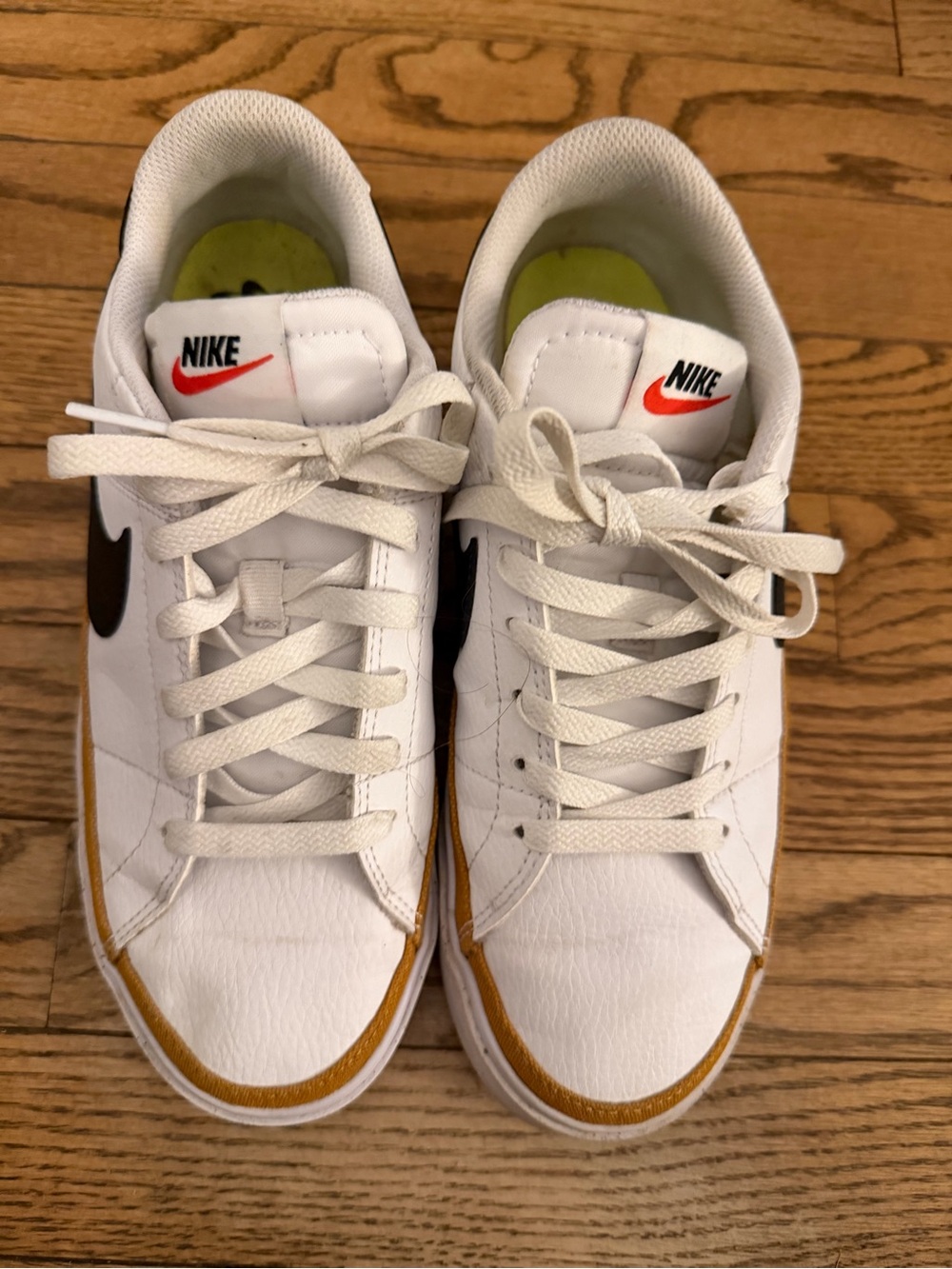 Nike White Sneakers with Black Swoosh and Gold Accent